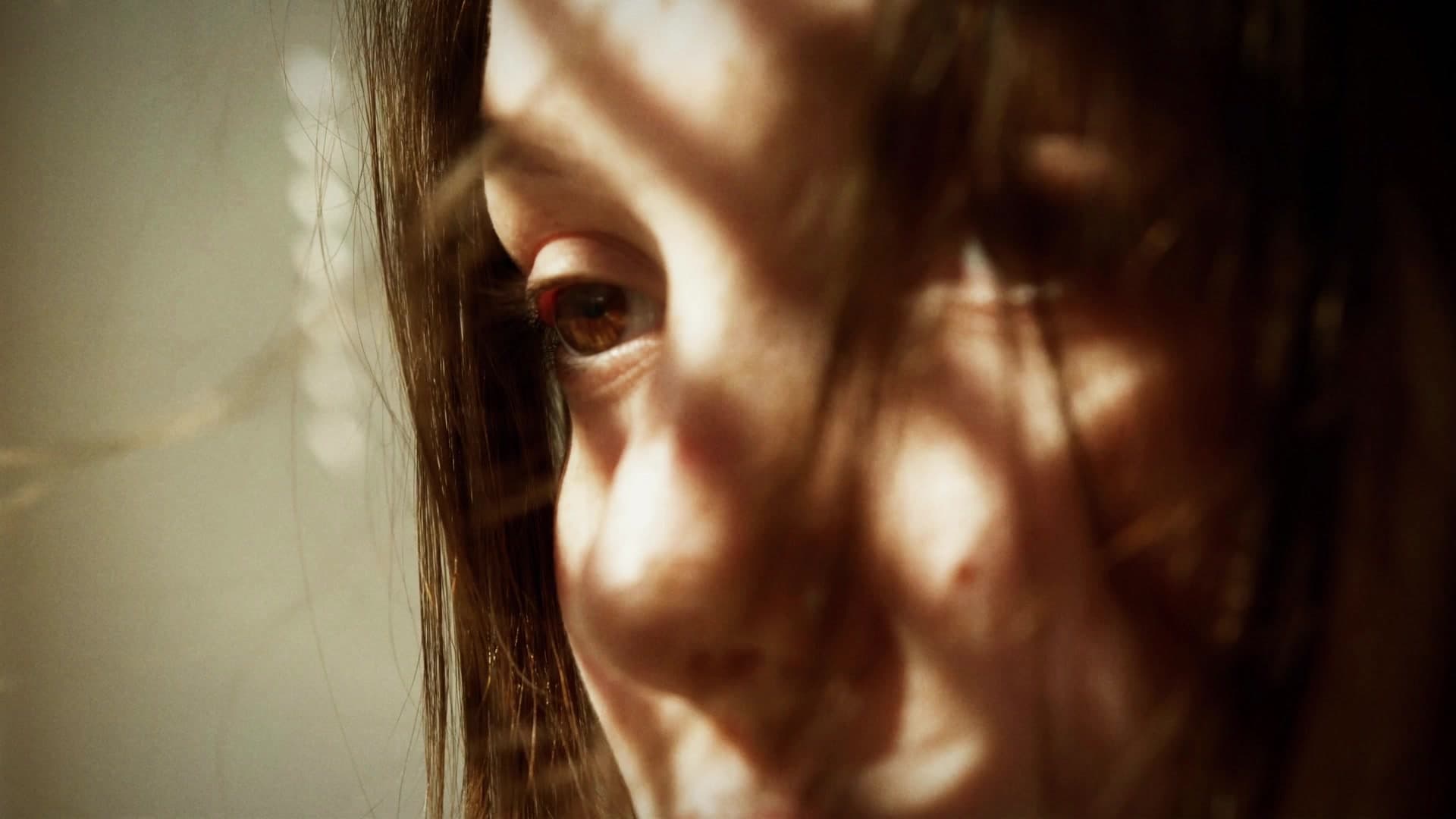 A woman's face in dappled, warm light