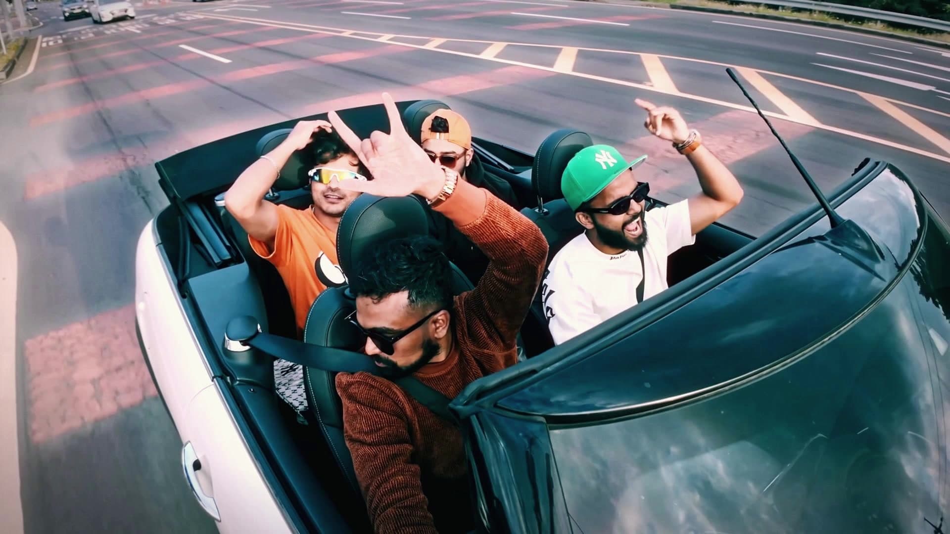 Friends laughing in a convertible on an open road