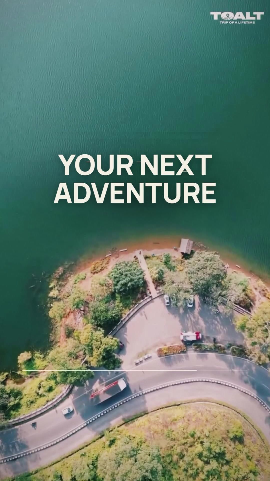 Aerial view of a road curving around a green island under YOUR NEXT ADVENTURE